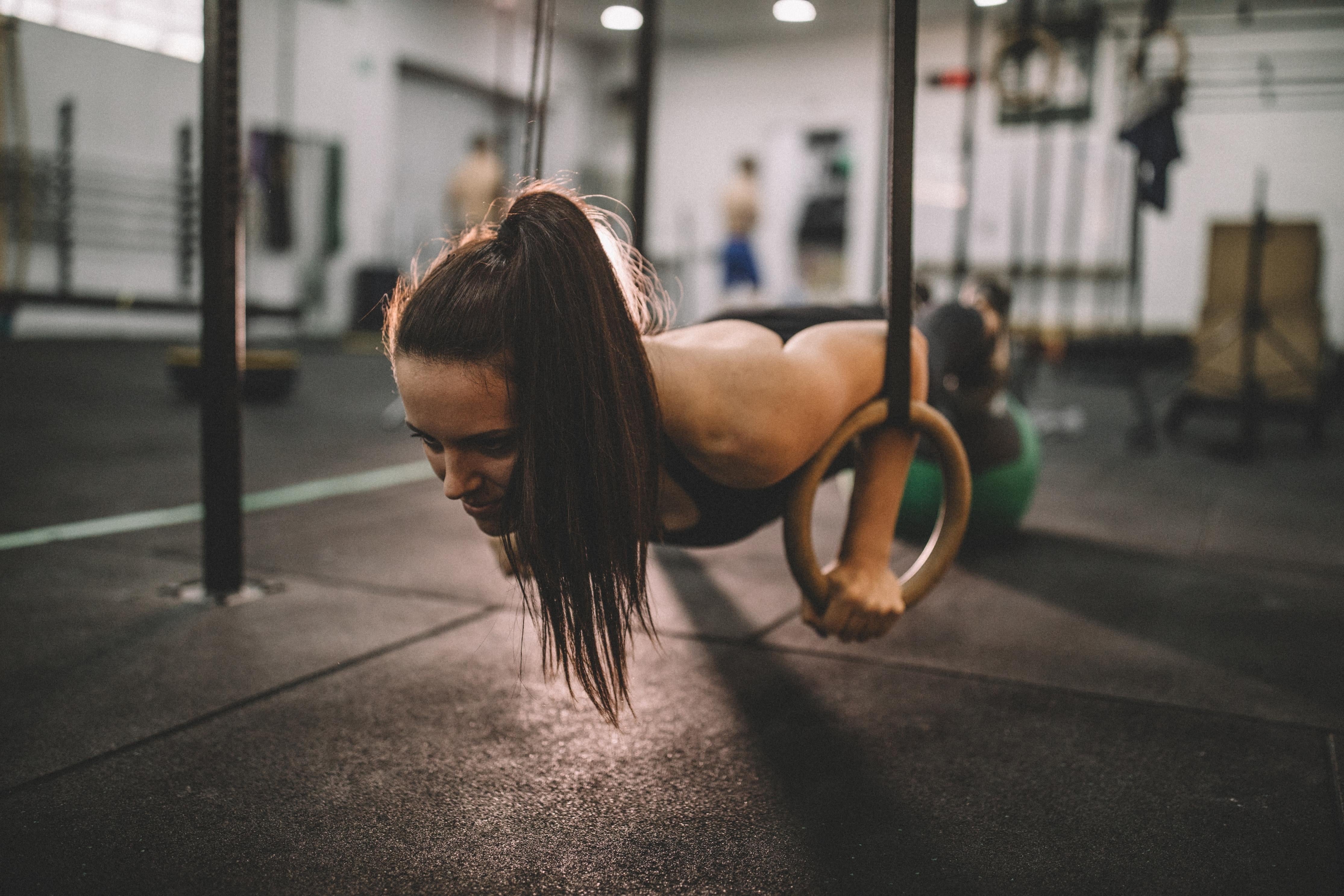 Woman doing a push up with gymnastic rings in a gym