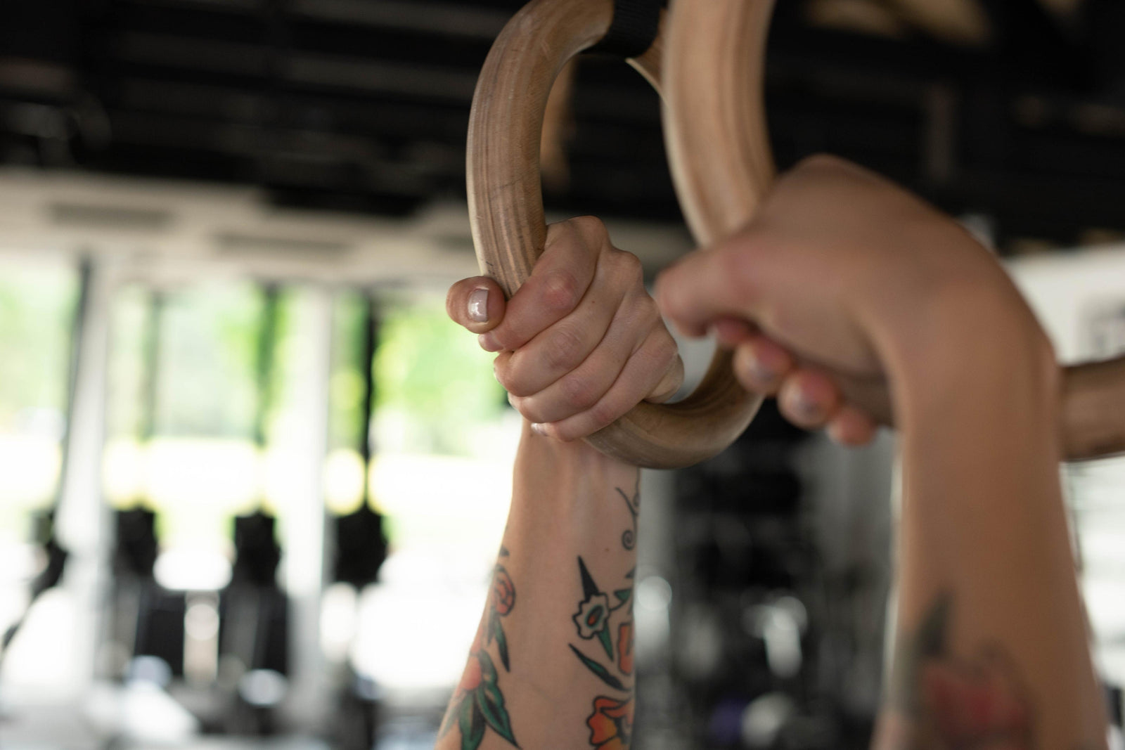 Hands gripping wood gymnastic rings