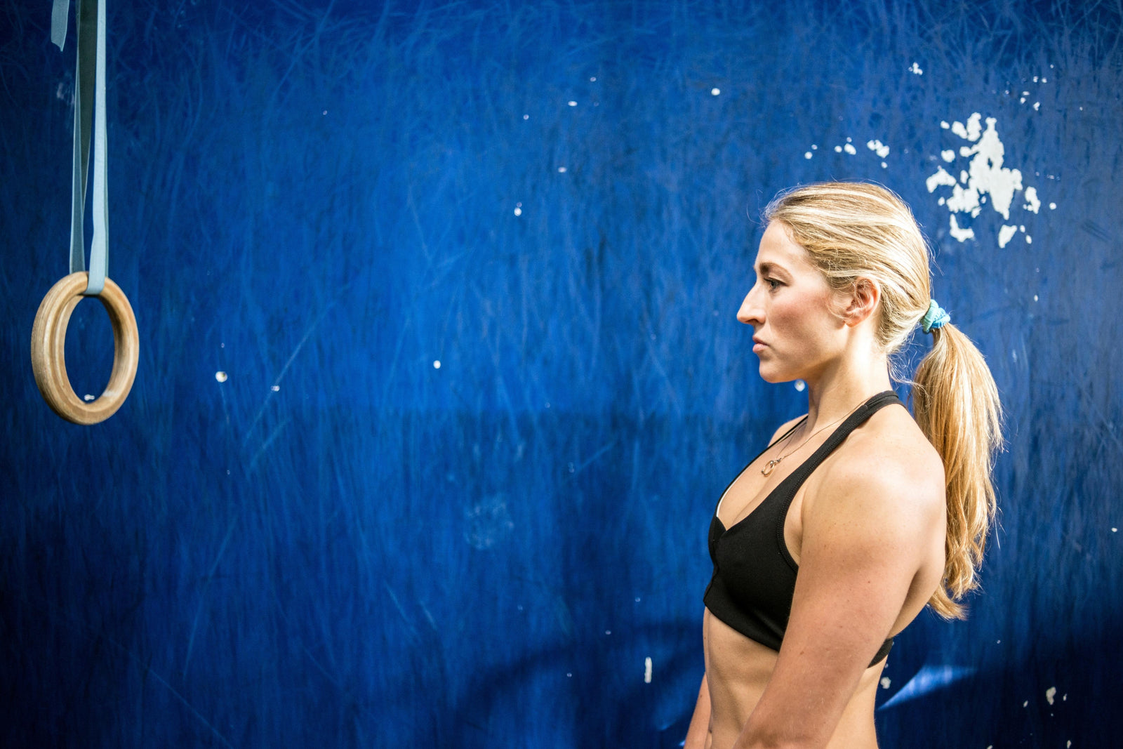 Strong fit woman look at gymnastic rings hanging at one metre distance.