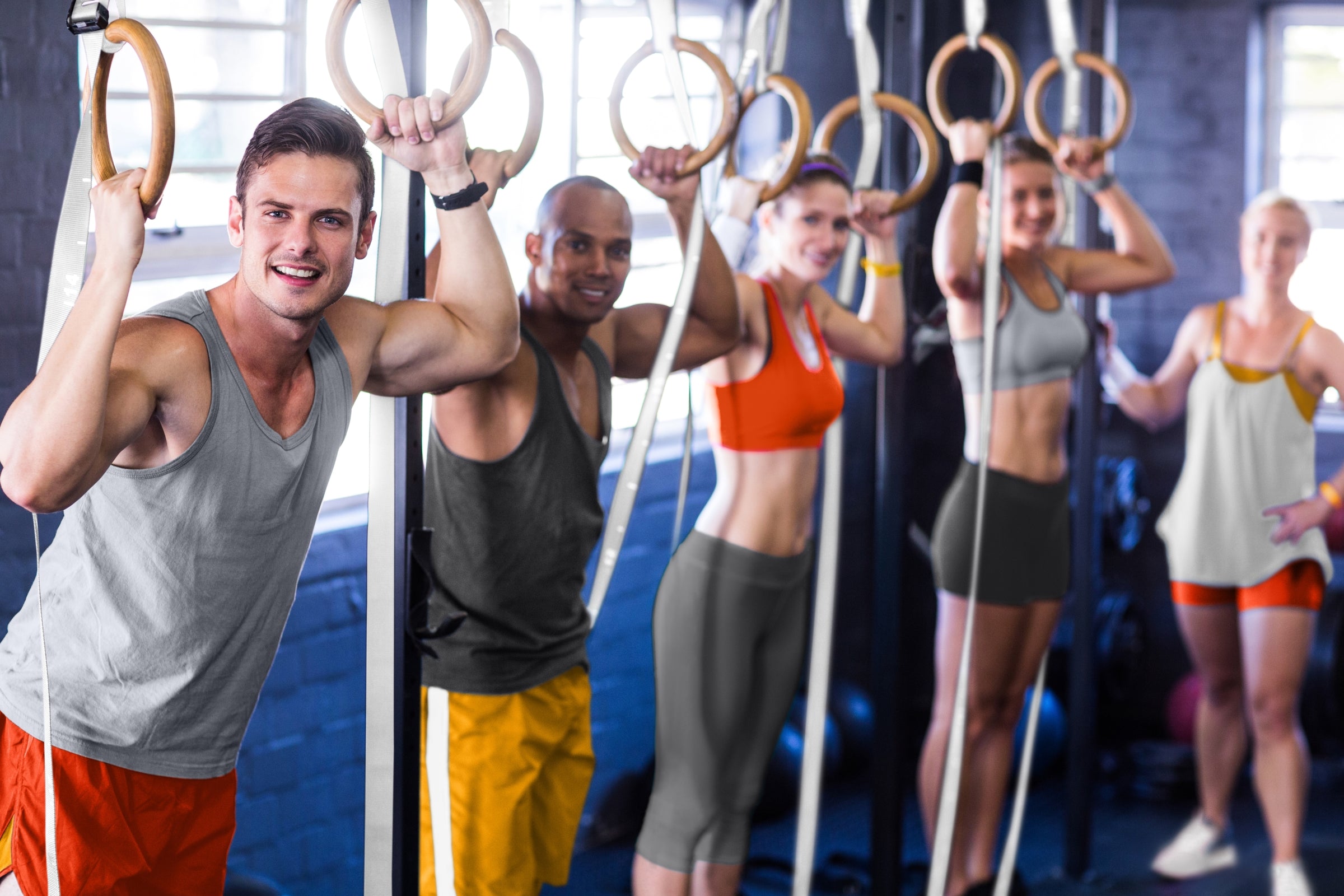 Men and women working out with wood gymnastic rings